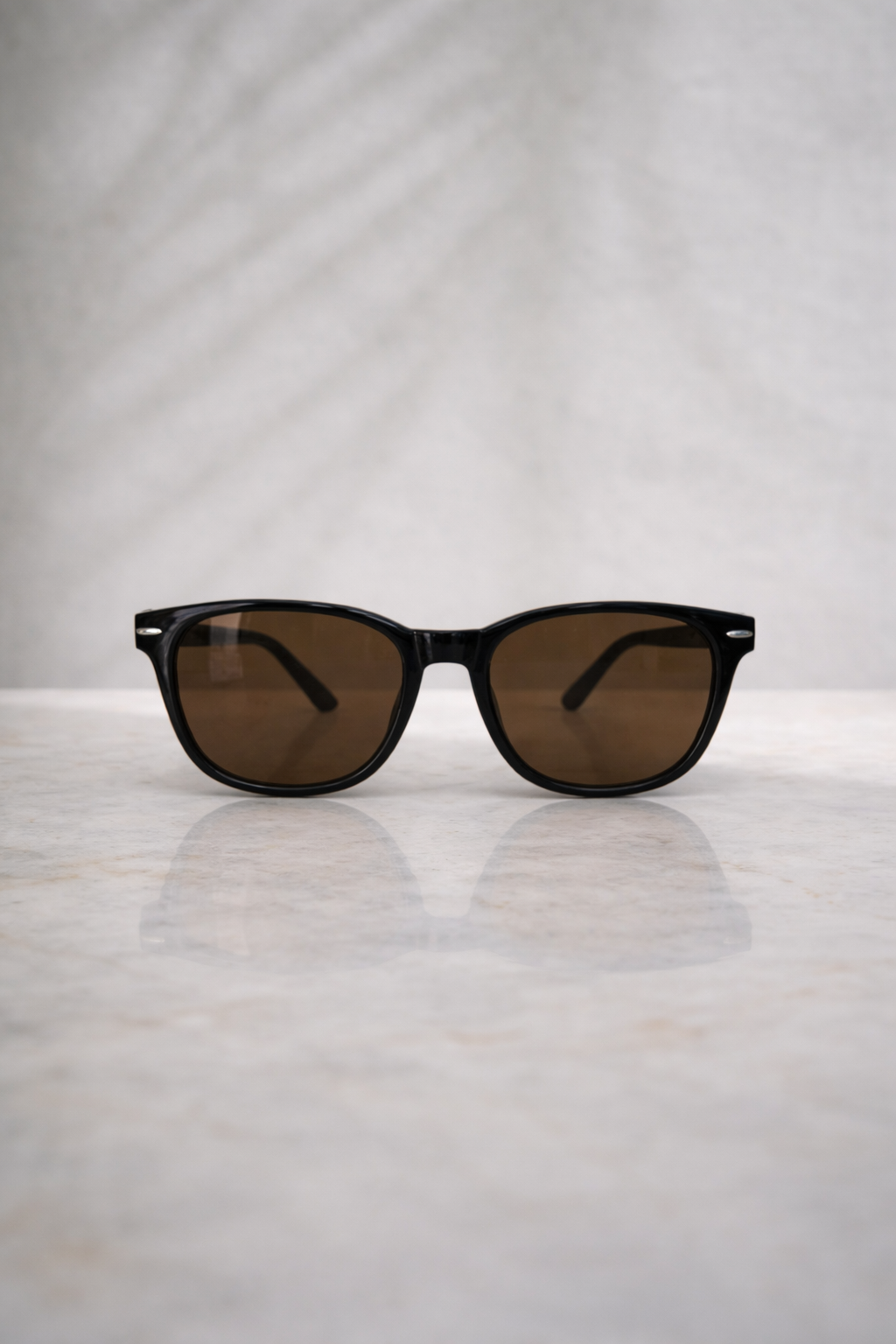Sunglasses with brown lenses on a light gray surface