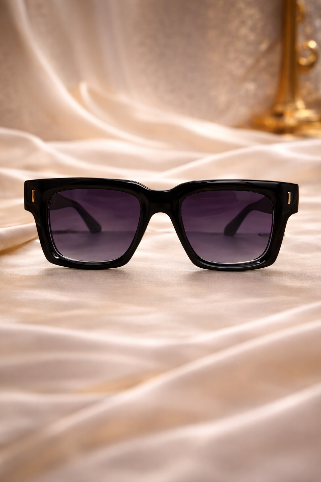 Black sunglasses with purple lenses on a beige fabric background