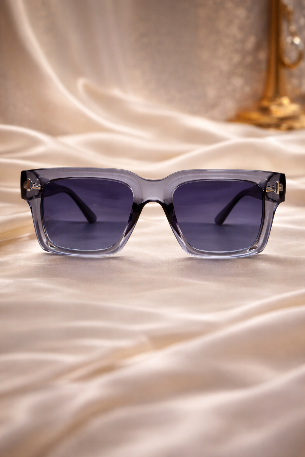 Sunglasses with gradient lenses on a satin surface