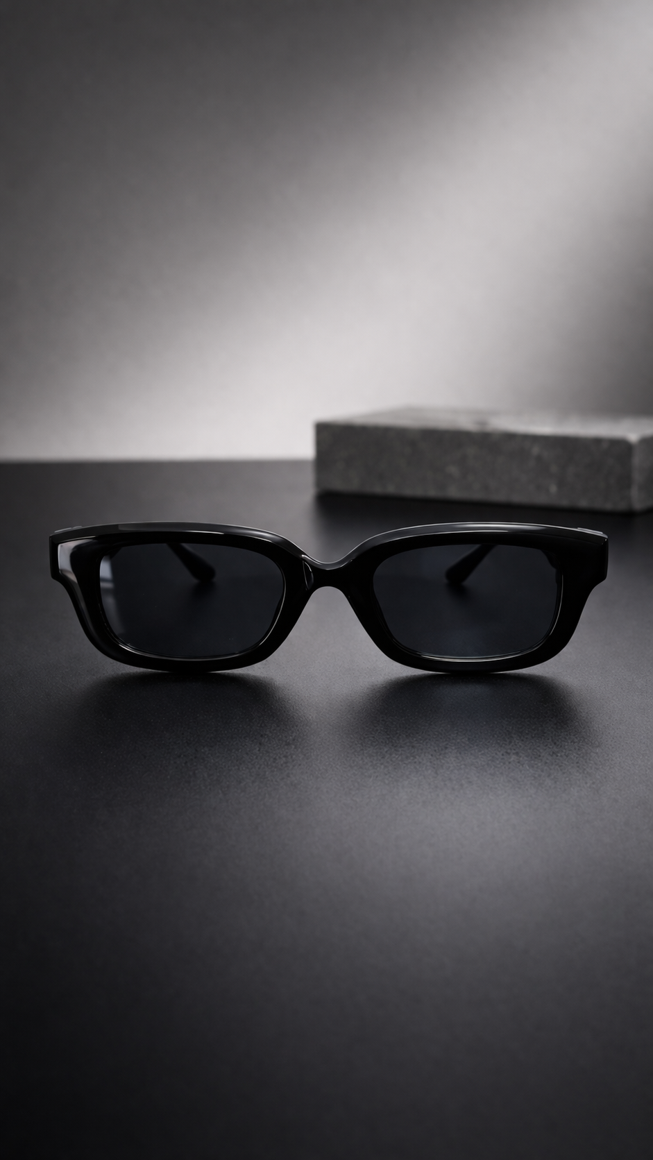 Black sunglasses on a reflective surface with a blurred background